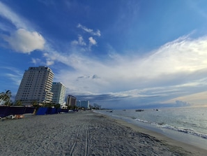 A beach with a sandy shore, a clear sky, and tall buildings in the background. - Grob Home Studio Apartment, just a few steps from the beach and the Zazué Shopping Center (Santa Marta)
