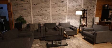 A living room with a brick wall, two sofas, a coffee table, and a lamp.