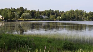 Una propiedad frente al lago con una casa, muelle y bosque circundante.