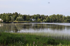 Una propiedad frente al lago con una casa, muelle y bosque circundante.