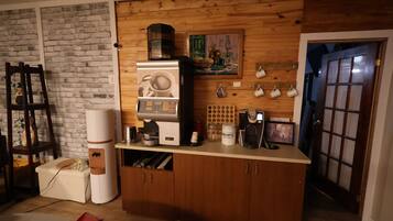 A kitchen with a coffee machine, a wooden cabinet, and a brick wall.
