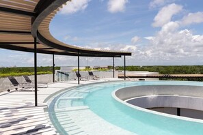 A rooftop swimming pool with lounge chairs and a covered seating area. - Ixchel Luxury PH Studio Priv Rooftop Pool 150 Wifi (Tulum)
