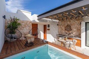 A modern outdoor pool area with a stone wall, seating, and a pergola. - Ixchel Luxury PH Studio Priv Rooftop Pool 150 Wifi (Tulum)