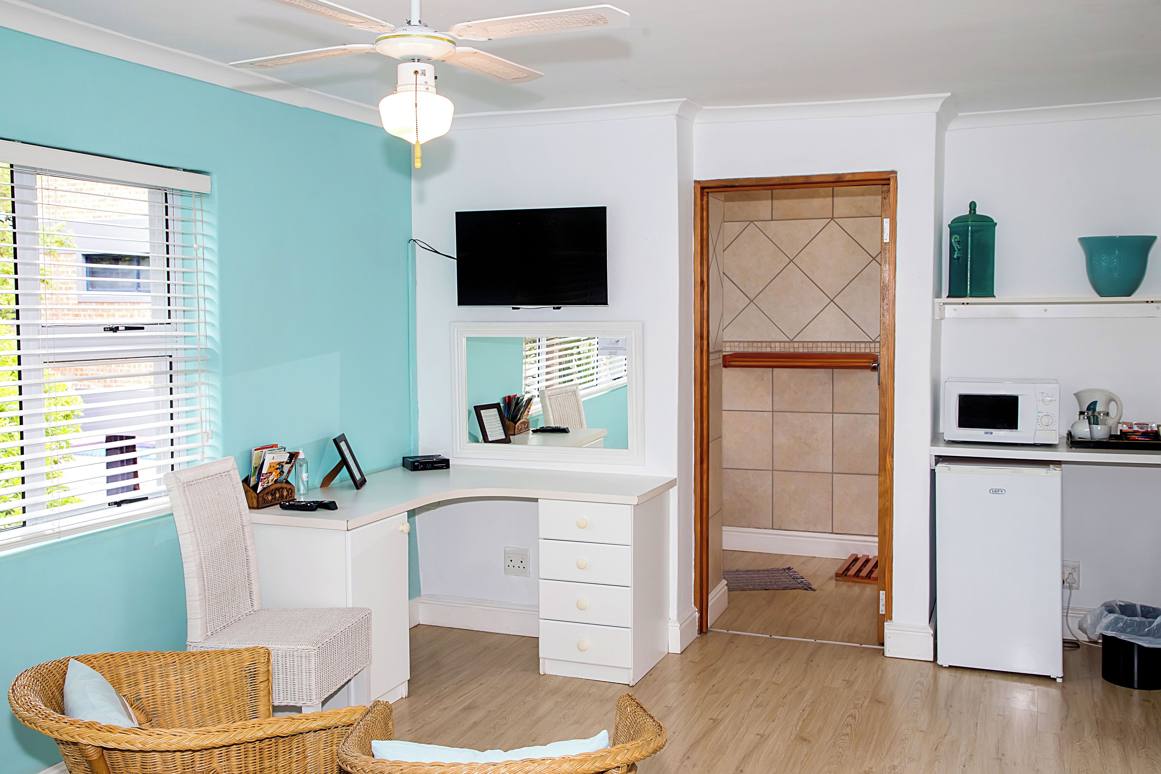 A modern kitchen with a white countertop, a microwave, and a small refrigerator.