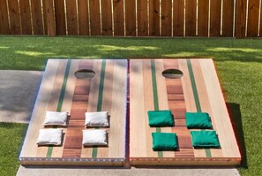 Two outdoor board games with holes for holding game pieces, placed on a concrete surface with grass around. - Nashville Dream Home - Near Downtown, Broadway, Midtown and Much More! (Nashville)