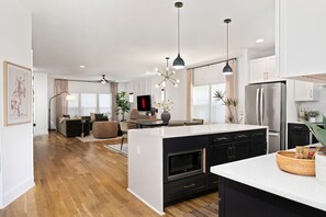A modern kitchen with a central island, black cabinetry, and a built-in oven. - Nashville Dream Home - Near Downtown, Broadway, Midtown and Much More! (Nashville)