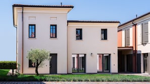 Un bâtiment moderne à deux étages, doté d’un toit plat, de nombreuses fenêtres et d’un petit arbre au premier plan.