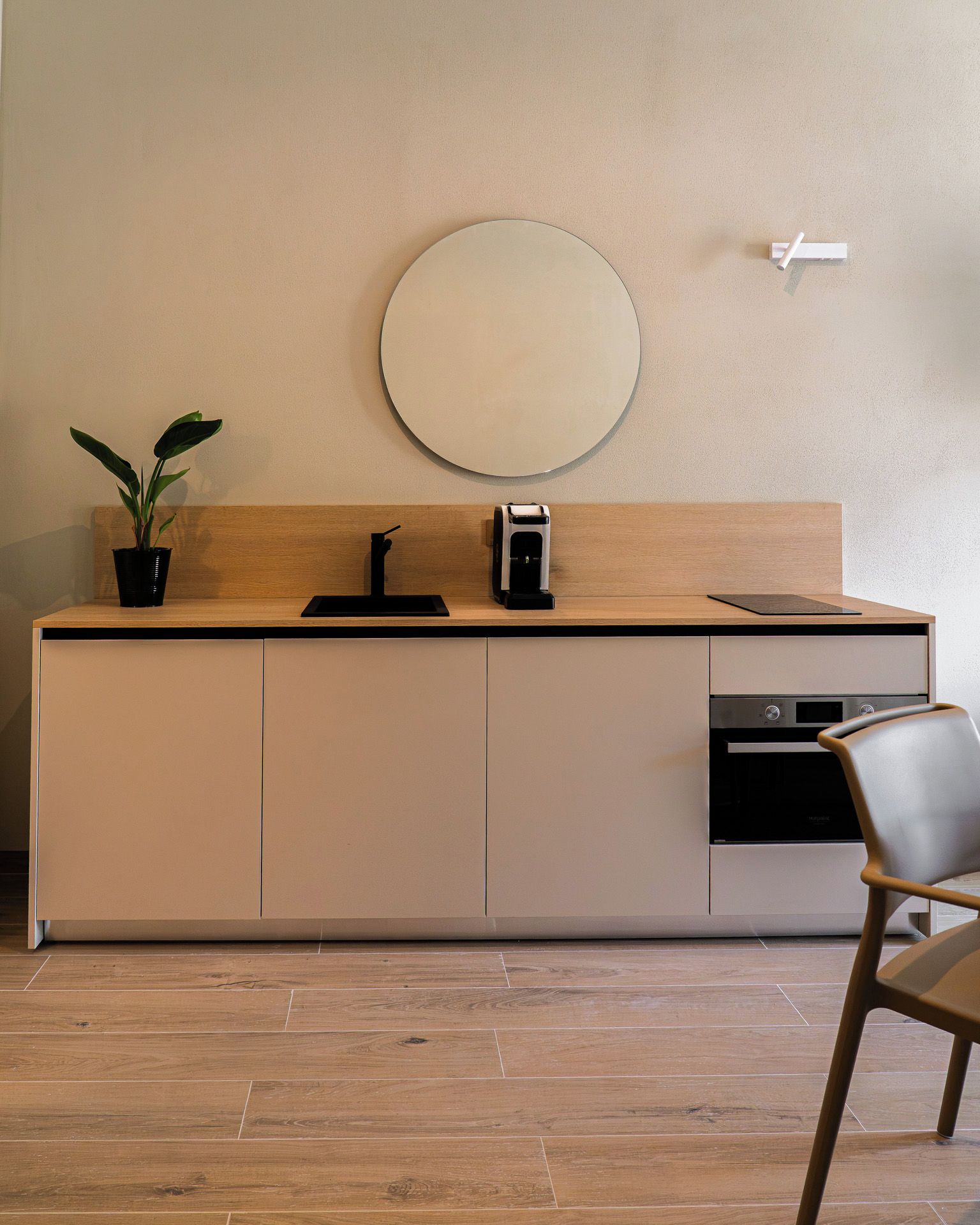 Una cocina moderna con encimera de madera, un lavamanos, una cafetera y un lavavajillas.