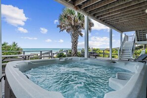 A hot tub with a view of the ocean, surrounded by a wooden deck and lounge chairs. - Seascape l Oceanfront l Hot Tub l Game Room (St. Johns County)