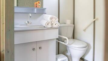 Een badkamer met een wit wastafel, toilet en een handgreep.