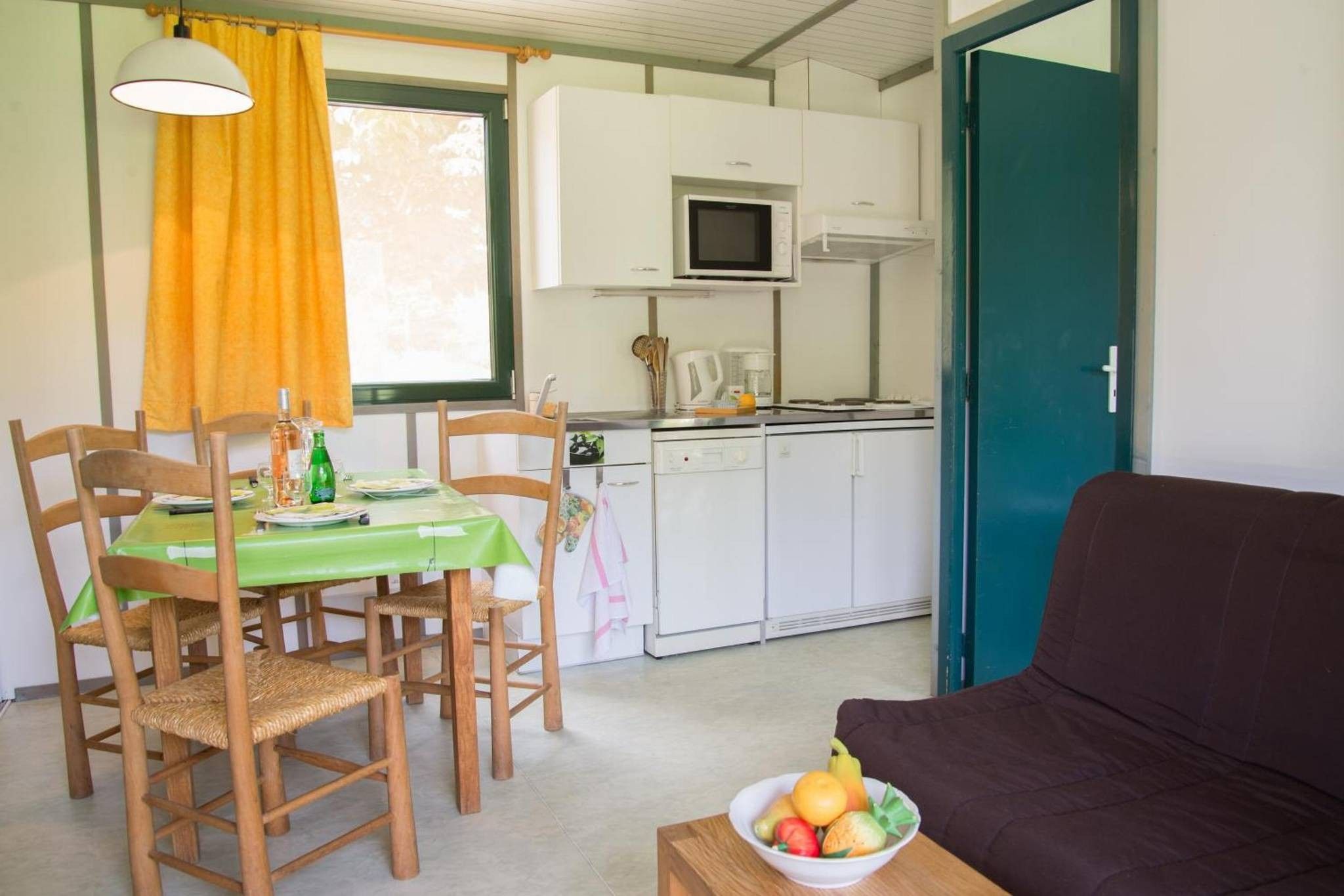 Un espace de vie compact comprenant un coin repas, une kitchenette et un canapé.