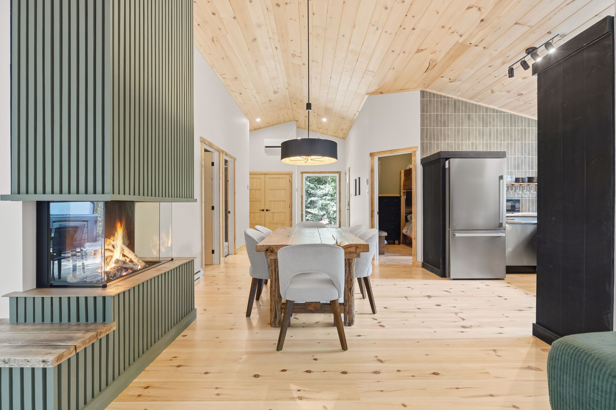 Une cuisine moderne dotée d’une cuisinière intégrée, de planchers en bois et d’un coin repas avec une table et des chaises.