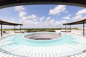 A rooftop infinity pool with a circular design, surrounded by lounge chairs and a covered area. - Boho Style Penthouse With Private Pool 150 Wifi (Tulum)