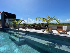 A swimming pool with clear water, surrounded by outdoor furniture and palm trees. - Xalet 307a Tulum Cenote y Beach Club Privileges (Tulum)