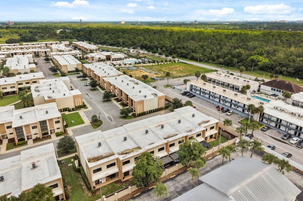 A residential complex with multiple apartment buildings, parking areas, and a swimming pool.