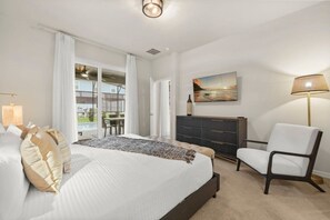 A bedroom with a bed, a chair, a dresser, and a painting on the wall. - Halloween Game Room! Sleeps 10 Windsor Cay - 1273 ER (Clermont)
