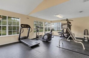 Ein Fitnessstudio mit Laufbändern, Crosstrainern und Gewichtsmaschinen.