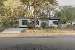 A modern single-story house with a flat roof, large windows, and a visible garage door.