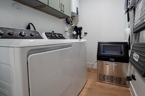A laundry area with a washing machine and dryer, a water heater, and a control panel.
