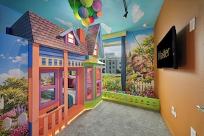 A children's playroom with colorful walls, a mural, and a TV mounted on the wall. - Relaxing Storey Lake Escape 3 BD/ 2 BA (3120-201PC) (Kissimmee)