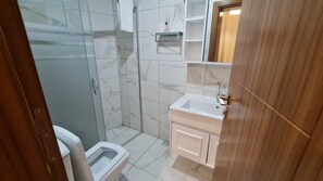 A bathroom with a toilet, a shower, and a sink. - Cozy 1BR Located Near the UNESCO World Heritage Green Masjid in Bursa City (Yıldırım)