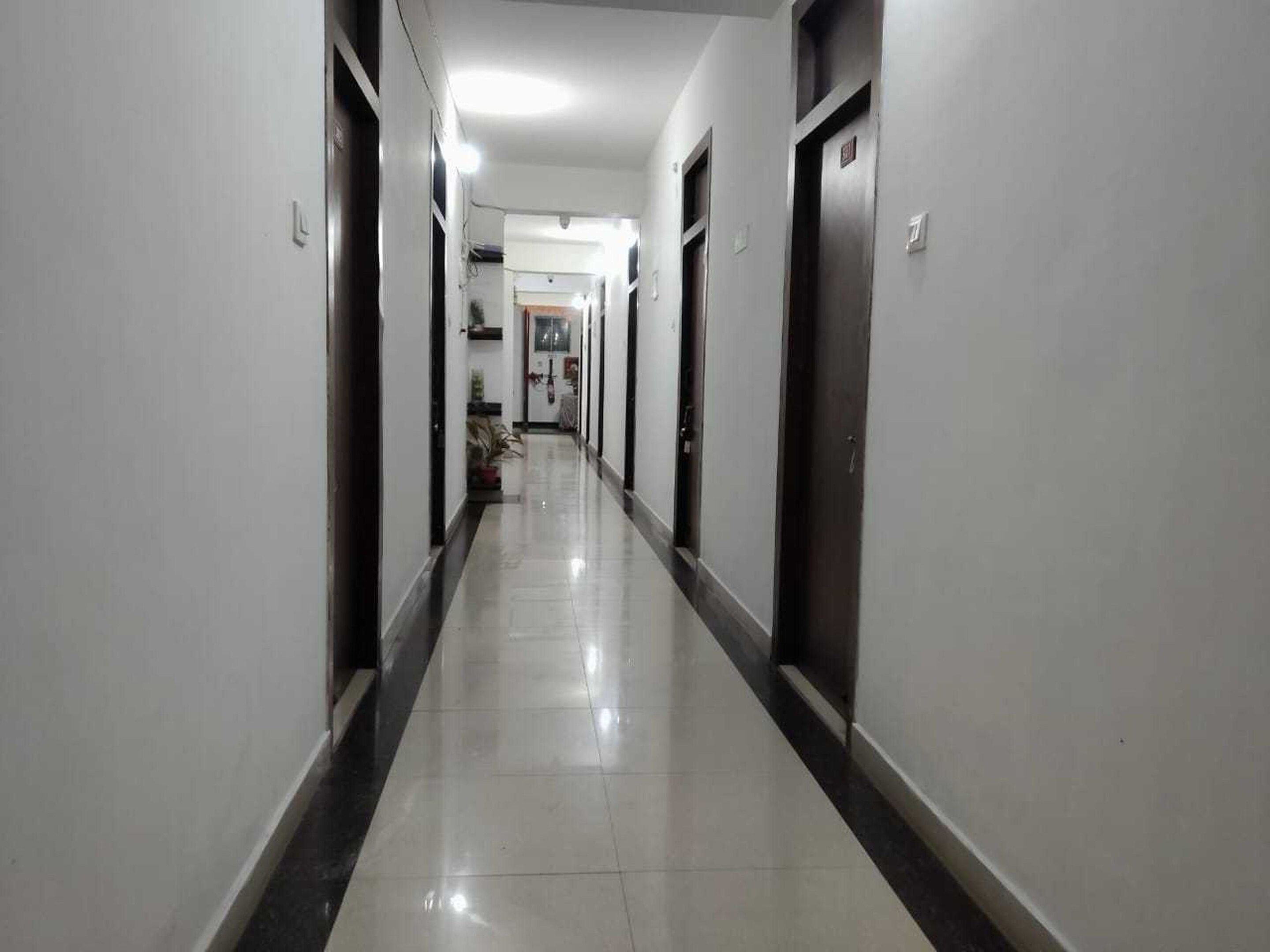 A long, narrow hallway with doors on both sides, leading to individual rooms.