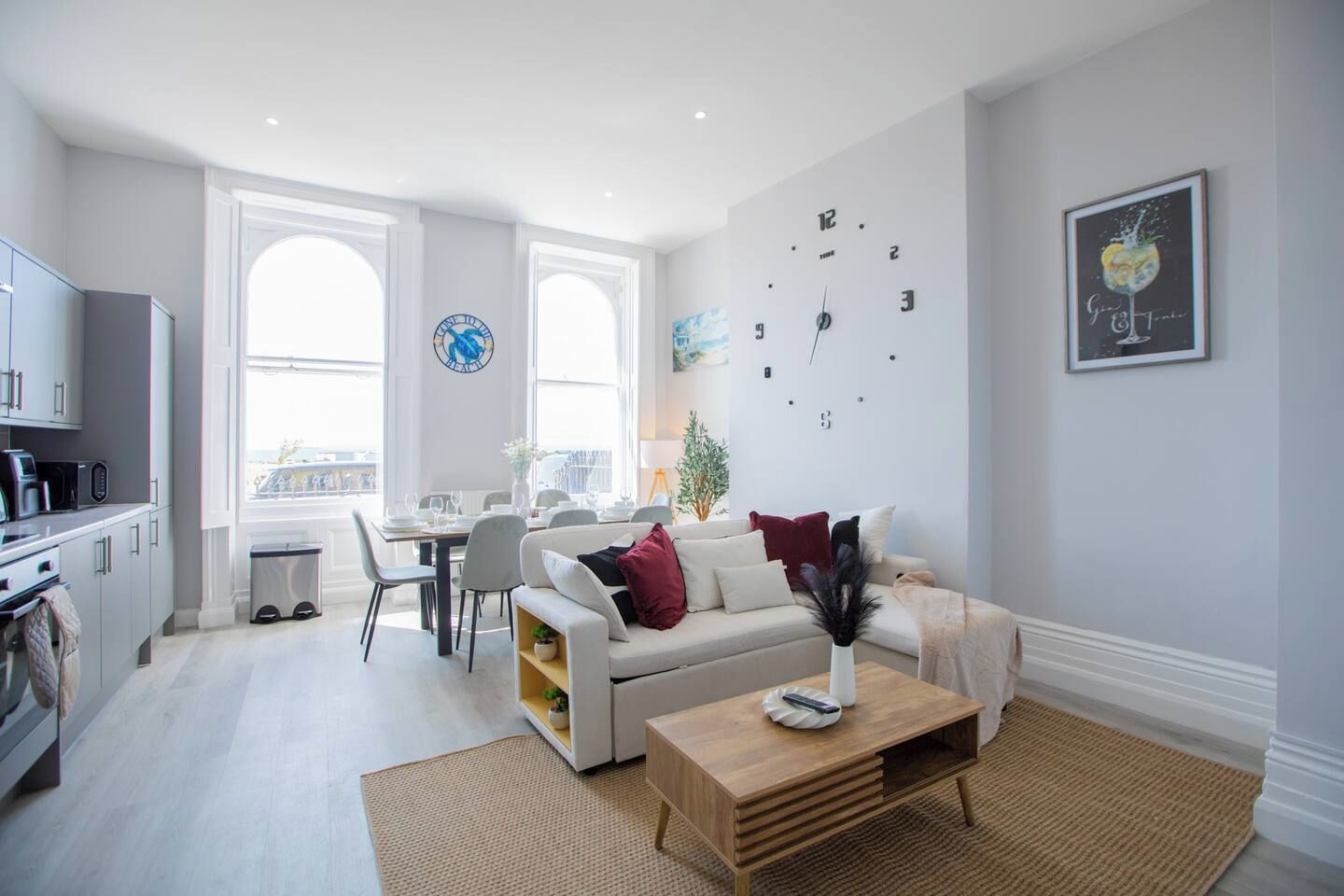 A modern living room with a sofa, coffee table, and dining area.