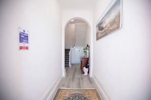Ein Flur mit einem Brandschutzschild, einem Teppich und einem Gemälde an der Wand.