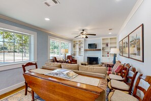 A spacious living room with a fireplace, a dining area, and a television.