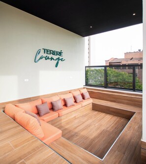 Un espace de détente moderne avec un canapé d’angle et une table basse en verre.