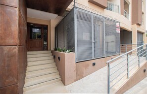 A building entrance with a set of stairs leading to a door, a metal gate with a sign, and a staircase railing. - Quiet Retreat, Full Kitchen & Desk, City Views (Asunción)