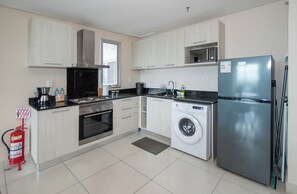 A modern kitchen with a stainless steel refrigerator, a built-in oven, a microwave, and a washing machine. - Quiet Retreat, Full Kitchen & Desk, City Views (Asunción)