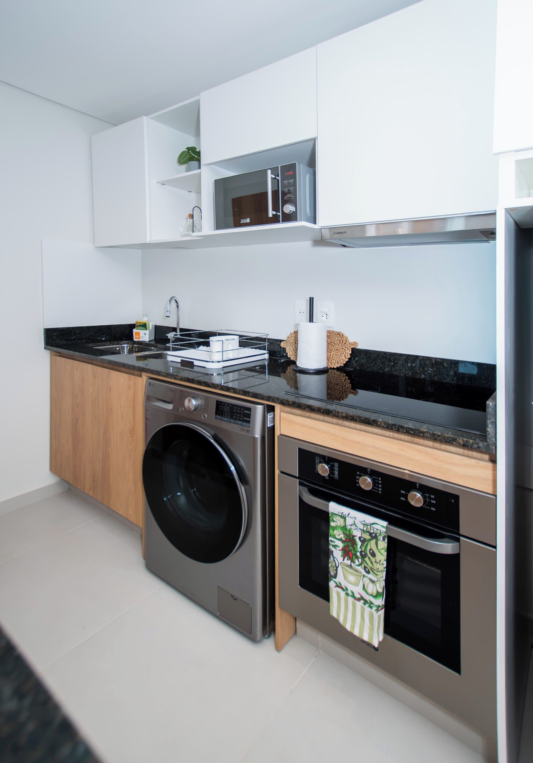 A modern kitchen with a built-in washer, oven, and microwave.
