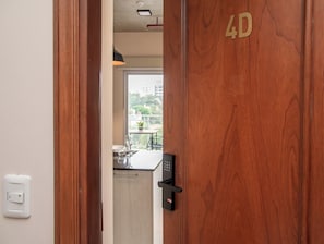 Uma porta de madeira com o número '4D' e uma maçaneta moderna.