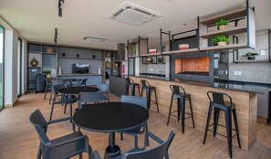 A modern kitchen with a dining area, built-in shelves, and a fireplace. - Modern Apartment, Workspace & Gym, Fast Wi-Fi (Asunción)