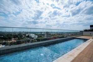 A rooftop swimming pool with a glass barrier, offering a view of the cityscape. - Modern Apartment, Workspace & Gym, Fast Wi-Fi (Asunción)