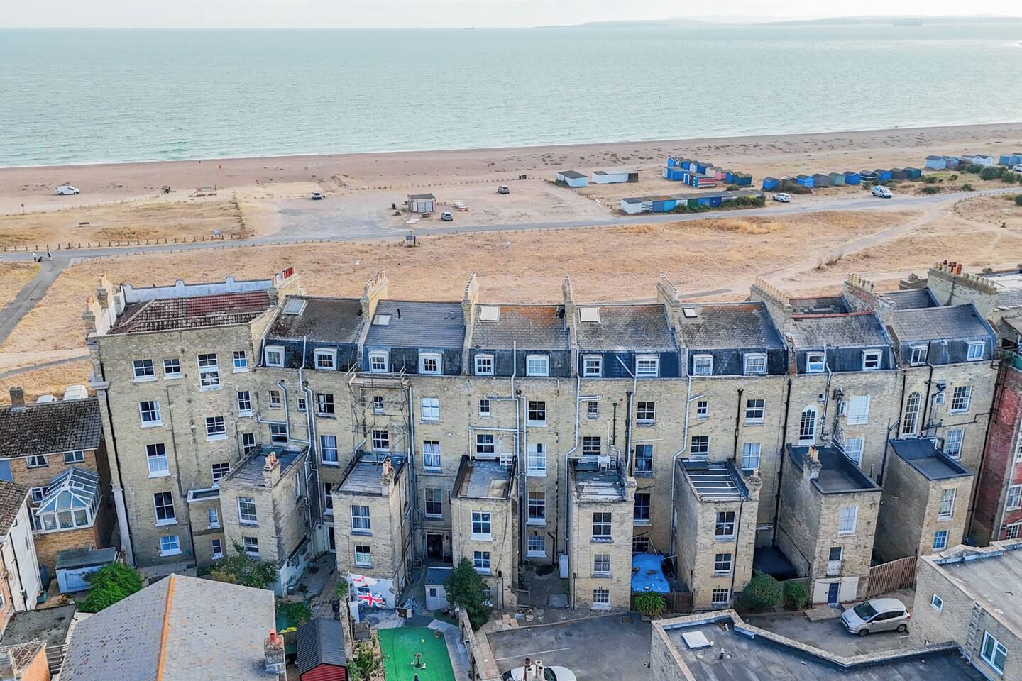 A multi-story building with a flat roof, located near a beach.