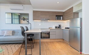 Eine moderne Küche mit Einbauofen, Mikrowelle und einem Edelstahl-Kühlschrank.