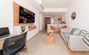 Um apartamento moderno com sala de estar, cozinha compacta e espaço para refeições.