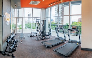 Ein Fitnessstudio mit Laufbändern, Kurzhanteln und Kraftgeräten.