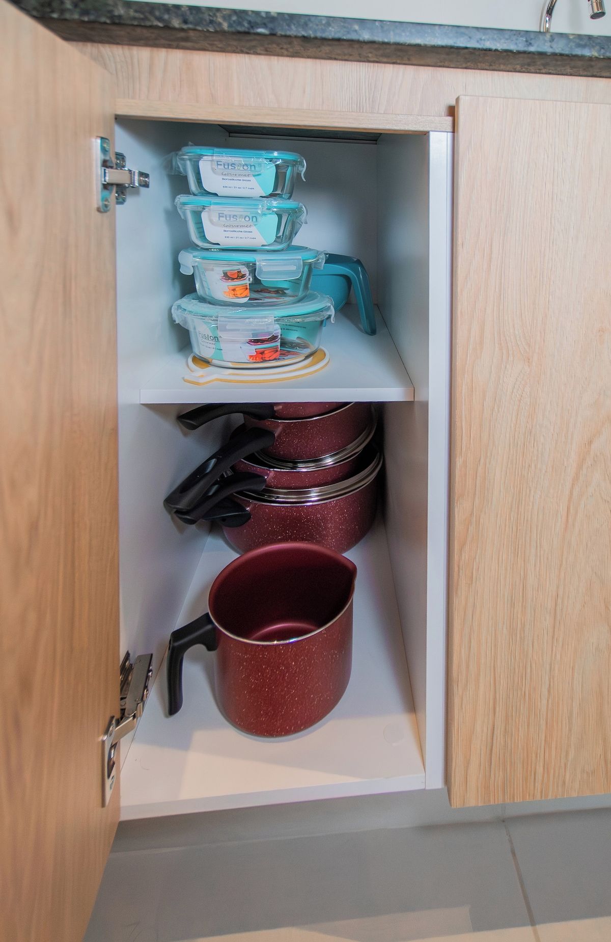 Eine Küchenschrank mit Aufbewahrungsbehältern und Kochgeschirr.