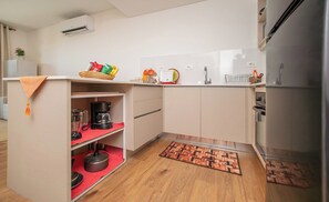 A compact kitchen with a built-in oven, a sink, and a refrigerator. - Prime Location One-Bedroom Near the Mall (Asunción)