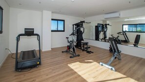 A gym with a treadmill, stationary bikes, and weight machines. - Modern 1BR in Boggiani | Pool, City Views & WiFi (Asunción)