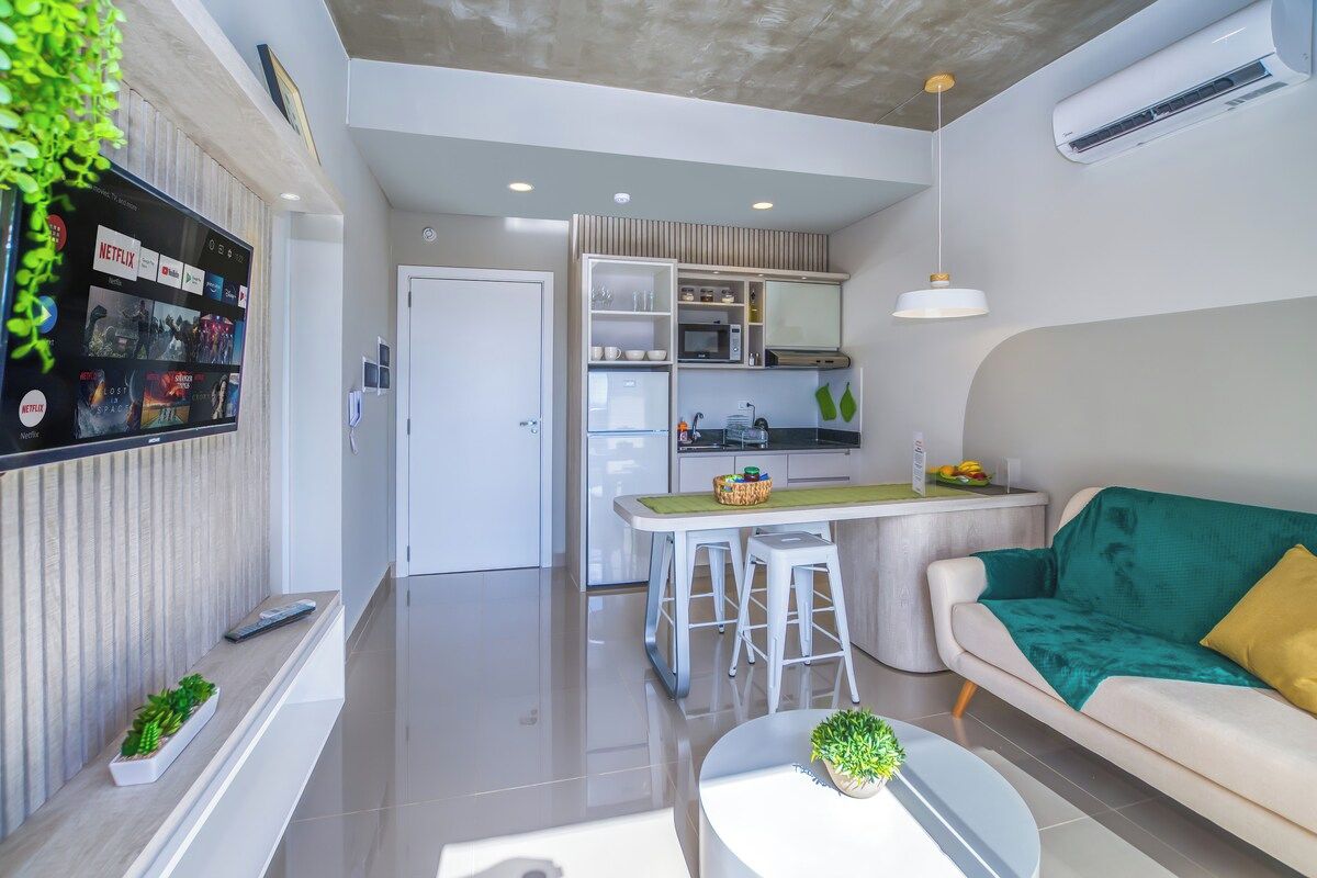 A modern living room with a sofa, a coffee table, and a TV mounted on the wall.