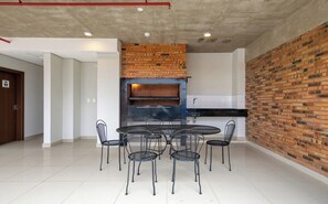 Une cuisine moderne avec un mur en briques, une table de salle à manger ronde entourée de chaises et un four encastré.