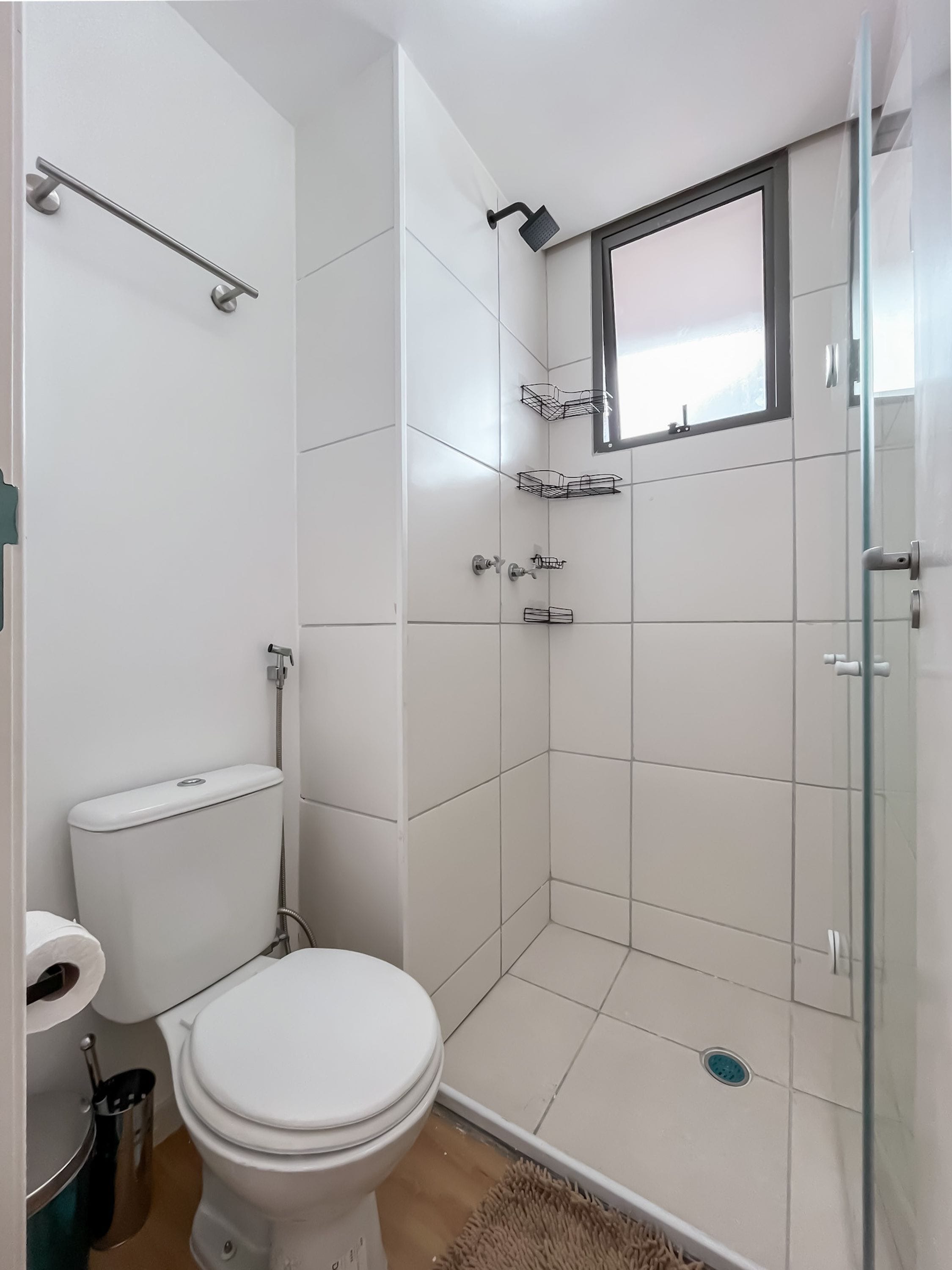 A modern bathroom with a toilet, shower, and glass door.