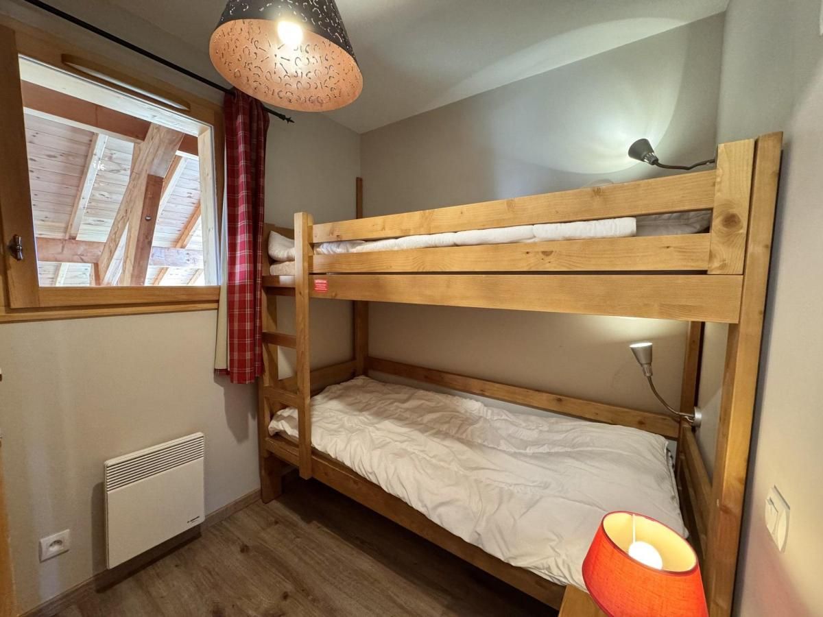 A bunk bed room with a window, a heater, and a lamp.