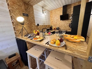 A kitchen with wooden walls, a countertop with food and drinks, a sink, and a hanging light fixture. - Ski-in/ski-out & foot of the slopes, 3rd floor, balcony, tv, 26m², Vars (Vars)
