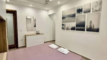 A bedroom with a bed, a bedside table, a mirror, and wall art.