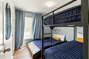 A bunk bed room with a window, curtains, and a door. - 4/2 Vacation Home at Windsor Palms!! (Kissimmee)
